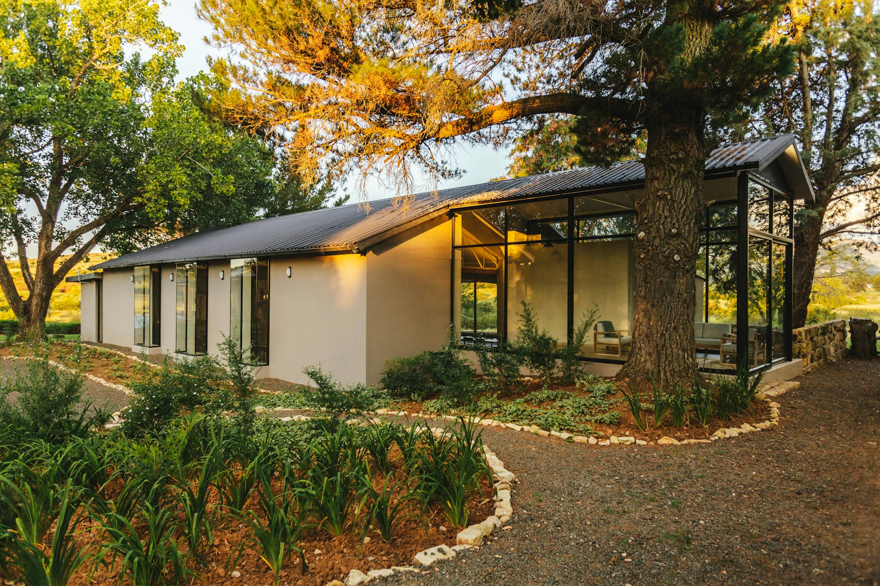 Maison contemporaine vitrée au milieu d’un jardin arboré
