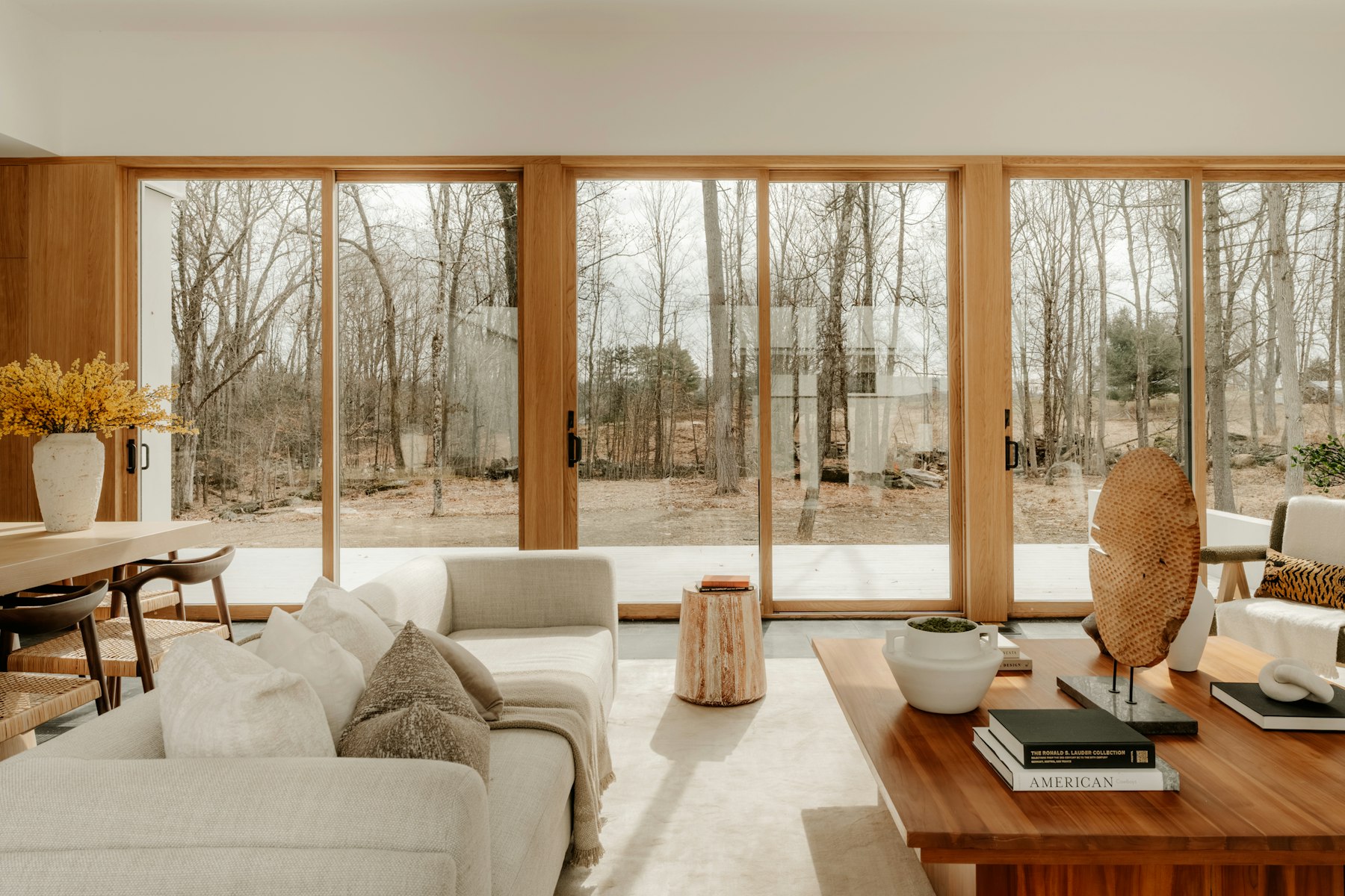 Séjour contemporain ouvert sur les arbres par de grandes baies vitrées